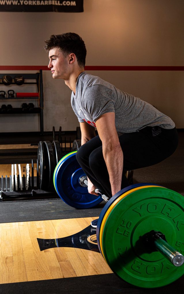 York Barbell Rubber plats on a bar with Man lifting
